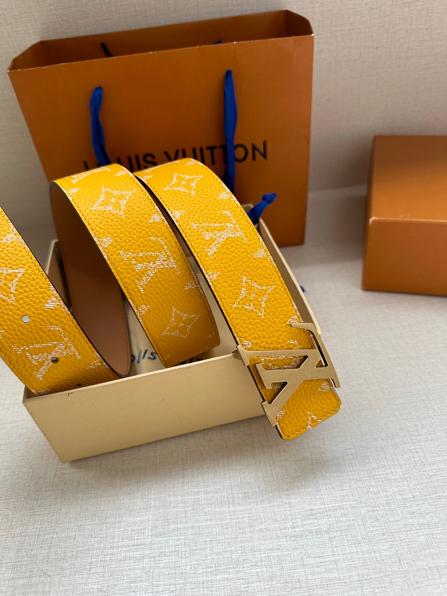 Yellow monogram leather belt with silver LV buckle, stacked strap angles