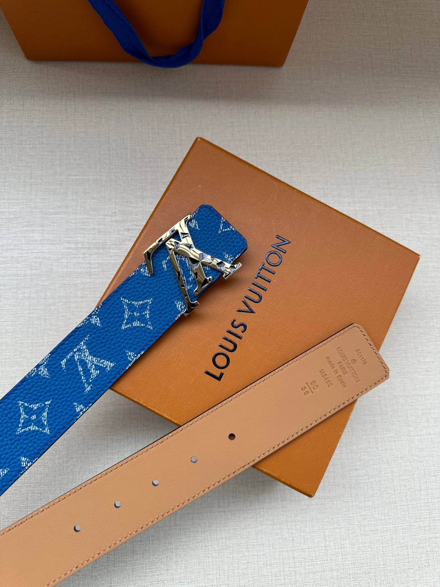 Louis Vuitton belt with blue monogram strap and tan leather reverse, gold buckle
