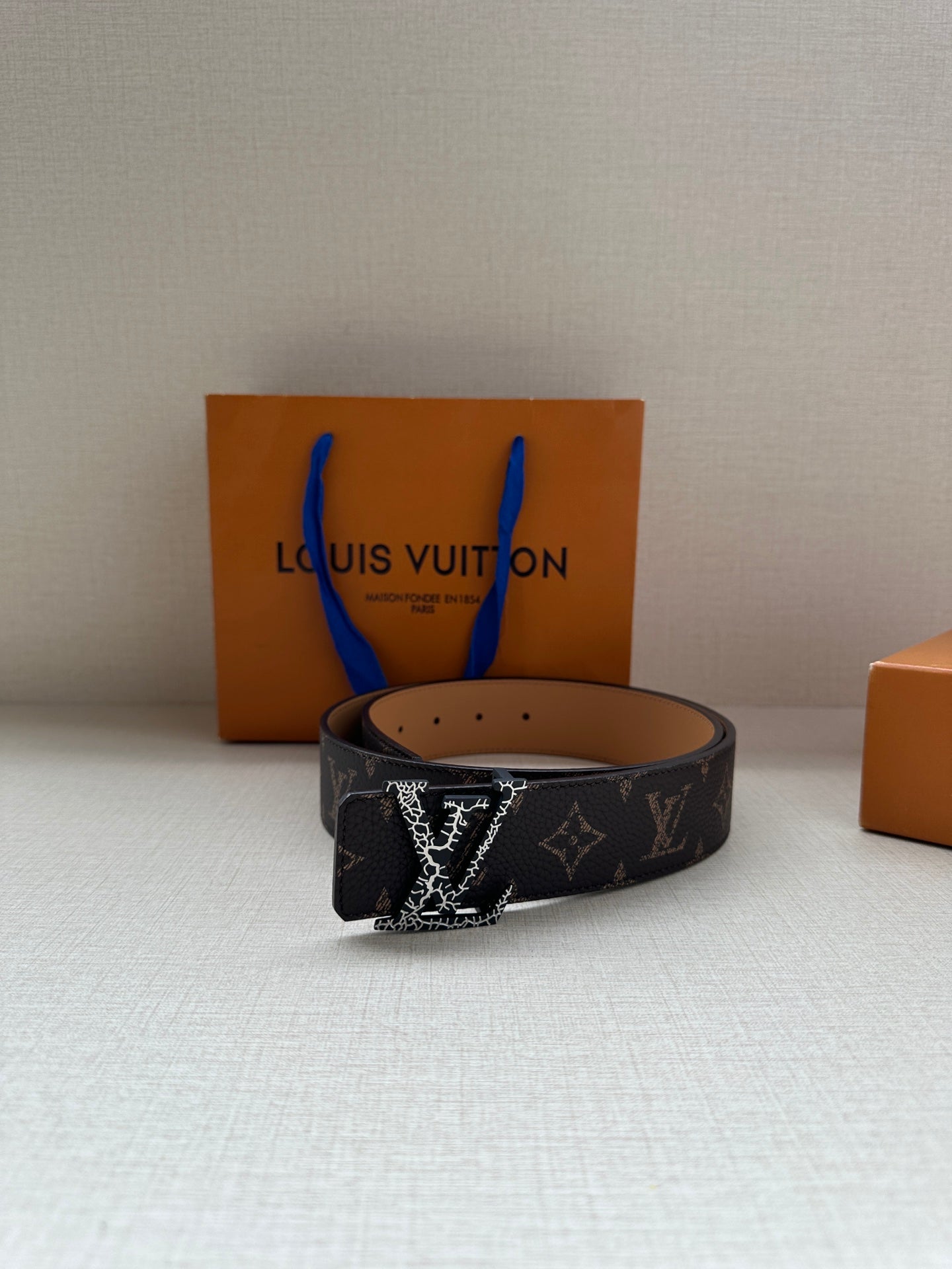 Louis Vuitton monogram belt with dark patterned strap and gold-tone buckle