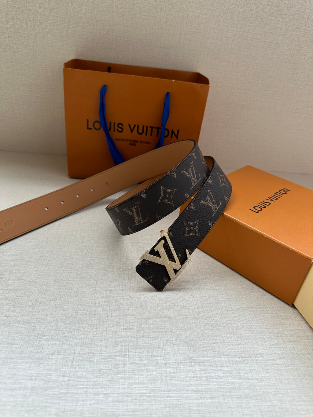 Louis Vuitton monogram belt with dark patterned strap and gold-tone buckle