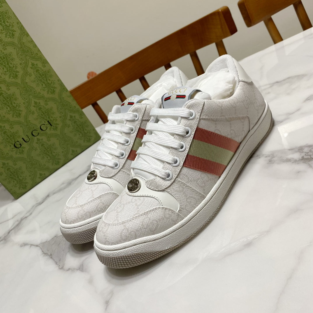 White Gucci unisex sneakers with red and green stripe on side, metal eyelets