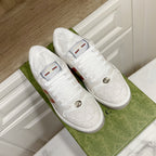 White Gucci unisex sneakers with woven pattern uppers and round metal logo details