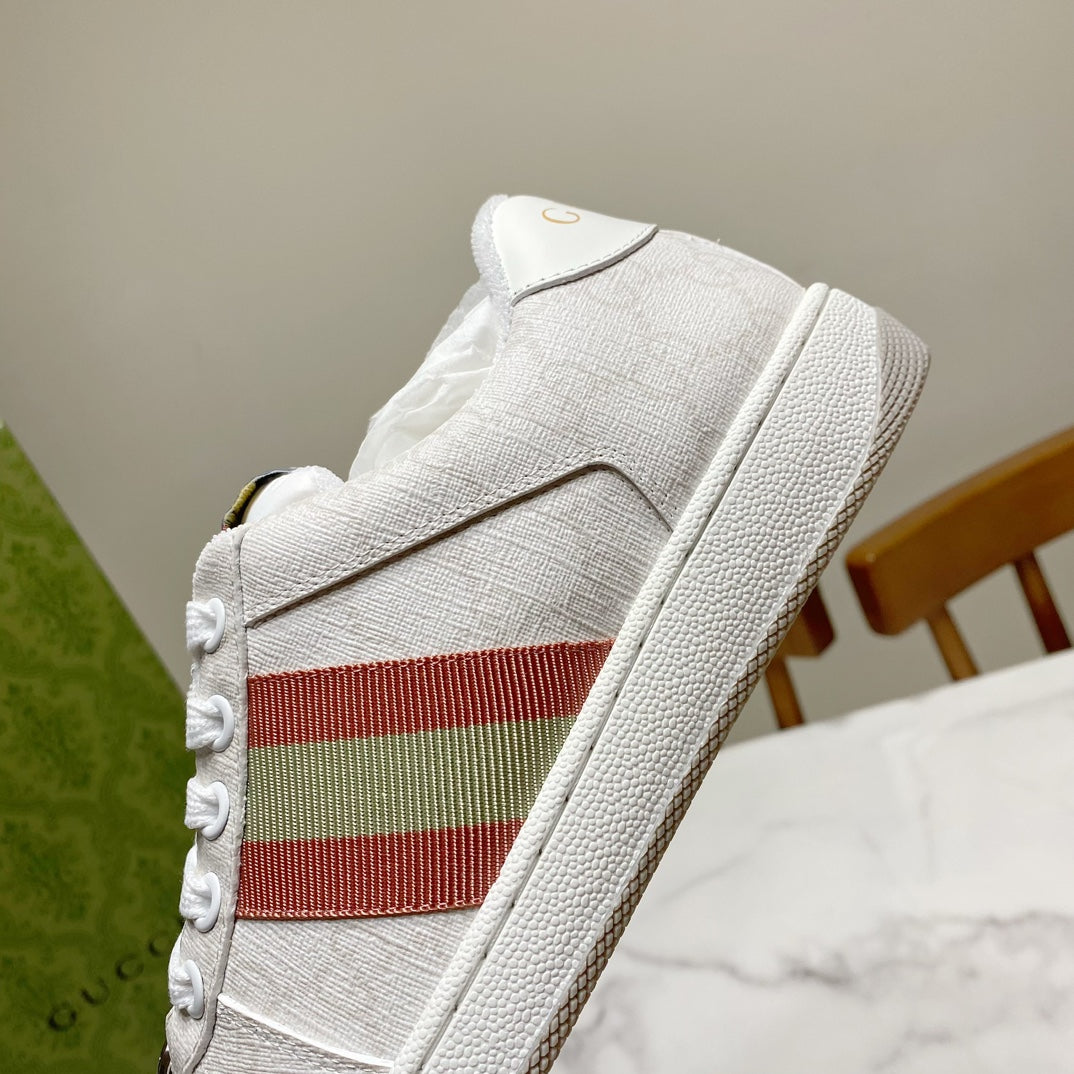 White Gucci unisex sneakers, close-up of side stripe panel and textured sole