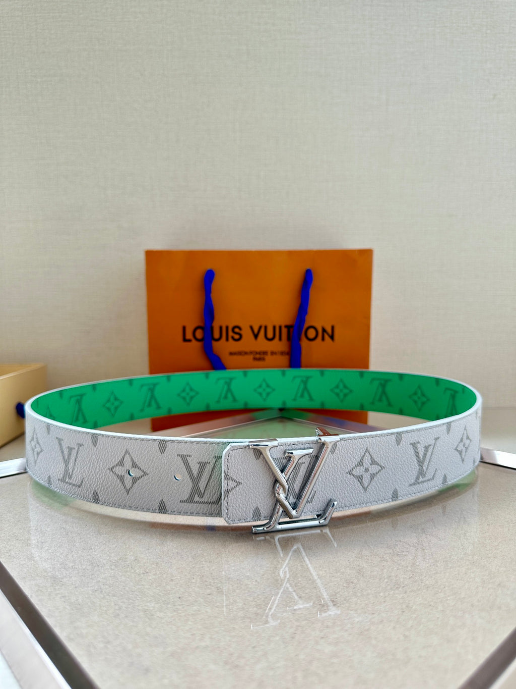 Louis Vuitton monogram belt in white with green trim and silver LV buckle, patterned.