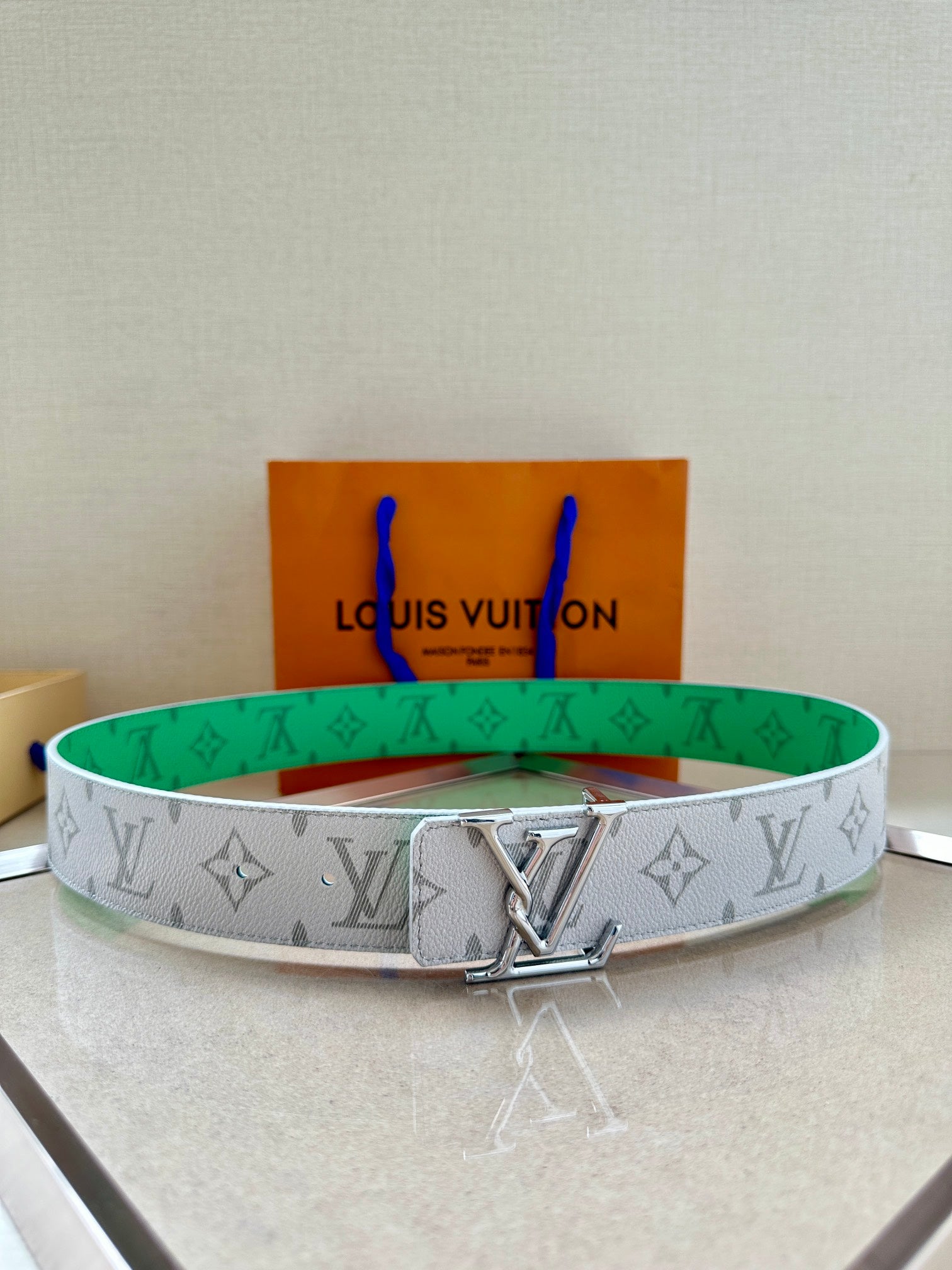 Louis Vuitton monogram belt in white with green trim and silver LV buckle, patterned.