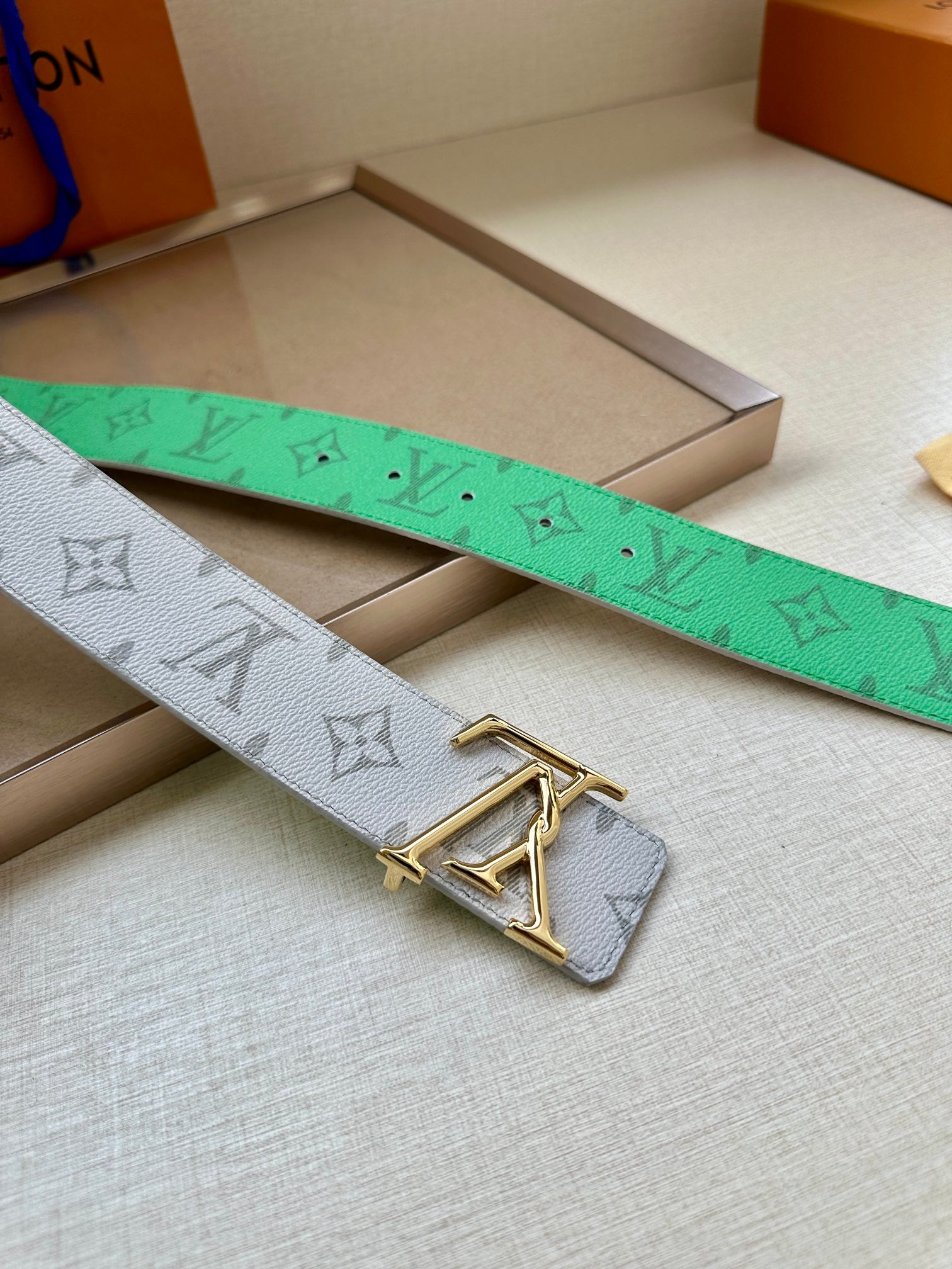 Louis Vuitton monogram belt in green and white with gold LV buckle and patterned strap.