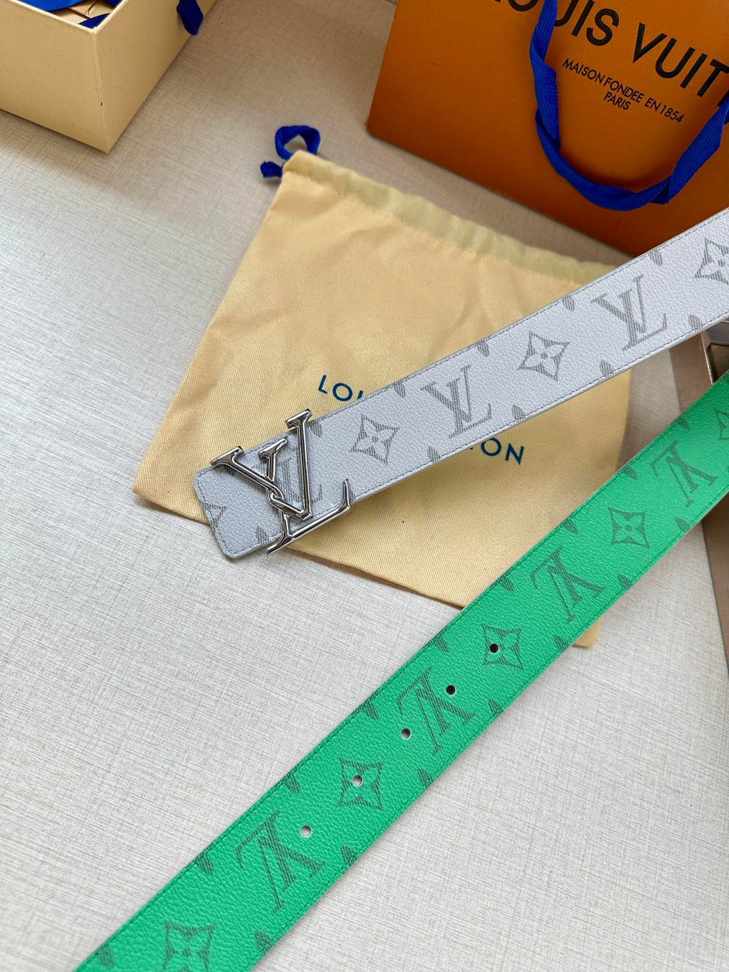 Louis Vuitton monogram belt in white with green underside and silver LV buckle.
