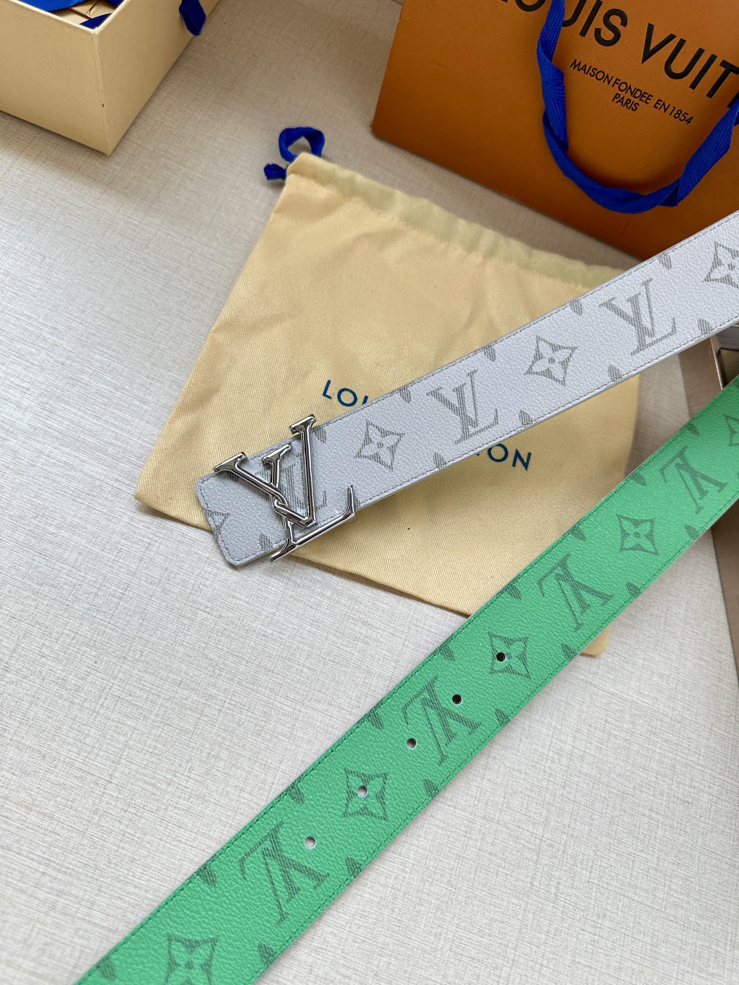 Louis Vuitton monogram belt in white with green underside and silver LV buckle.