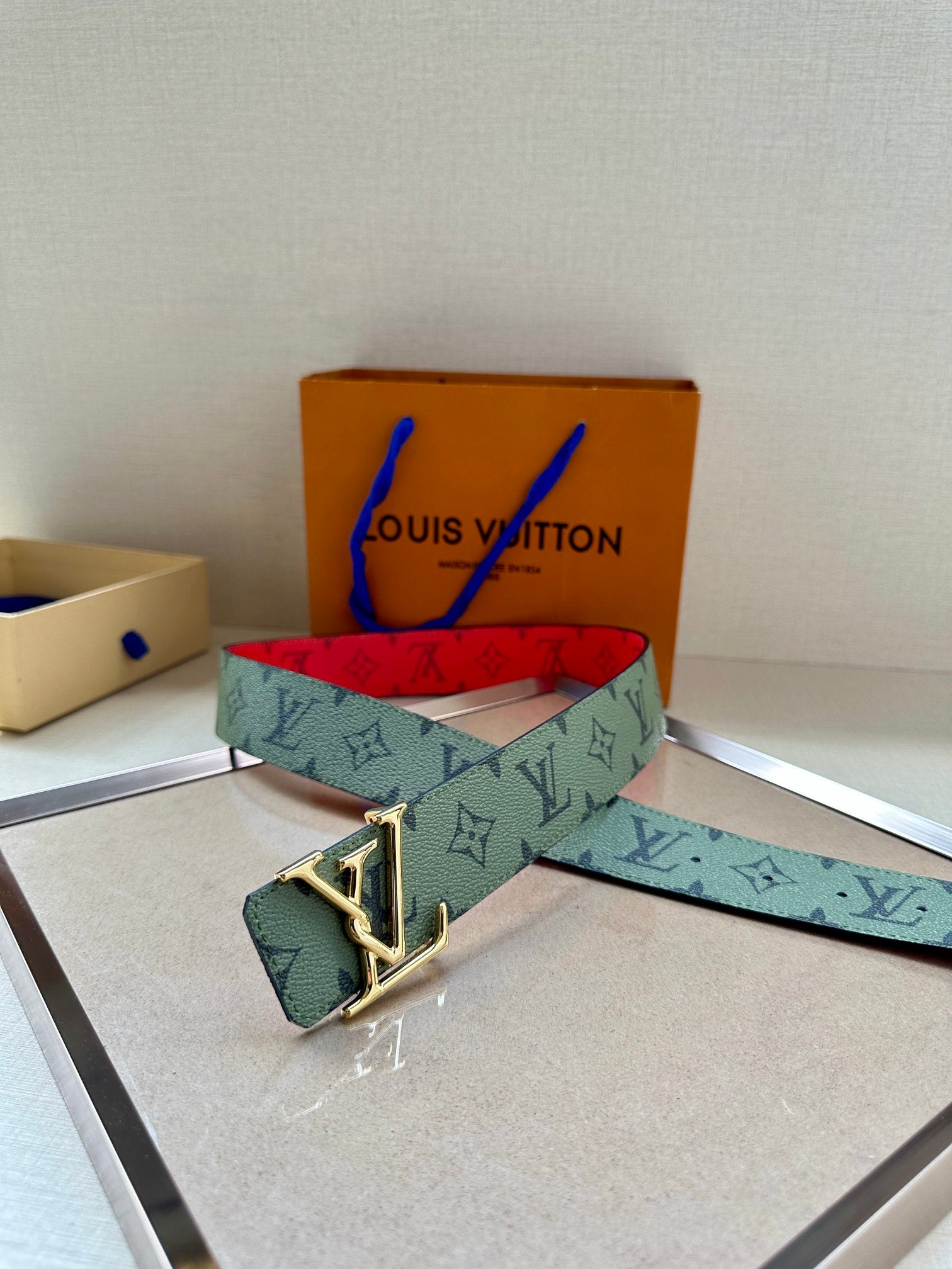 Louis Vuitton belt with mint monogram strap and gold-tone buckle, red interior