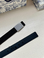 Navy leather belt with silver buckle section and strap with adjustment holes, side view.