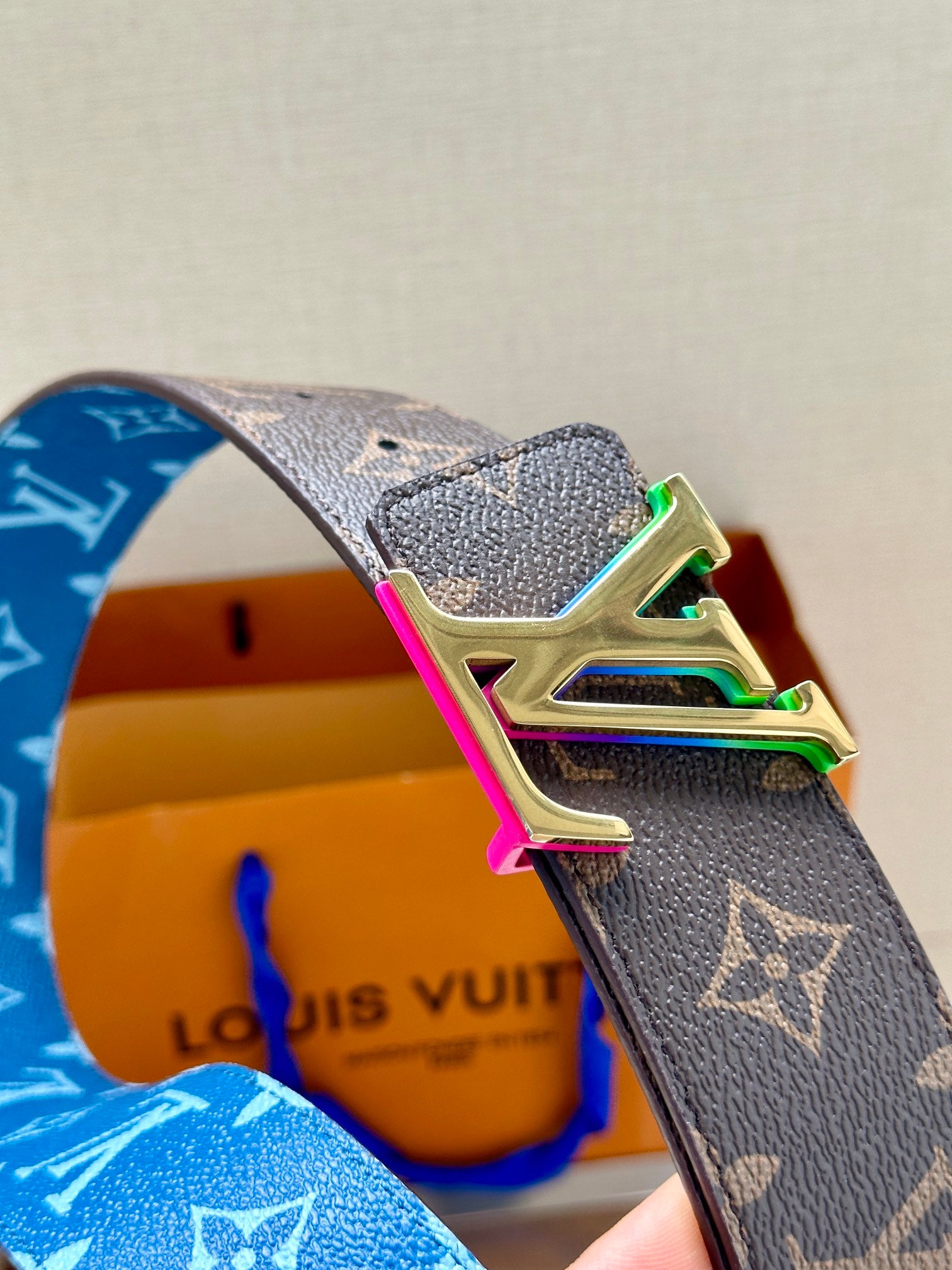 Louis Vuitton belt buckle close-up on blue monogram strap, LV multicolor hardware