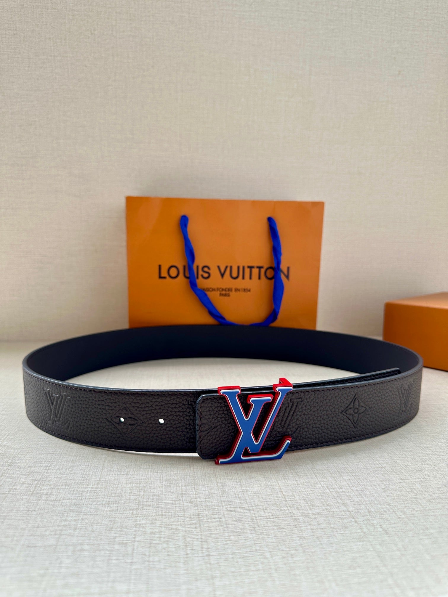 Louis Vuitton leather belt with textured strap and LV logo buckle, dark blue