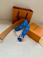Blue monogram belt with tan leather strap and metal buckle