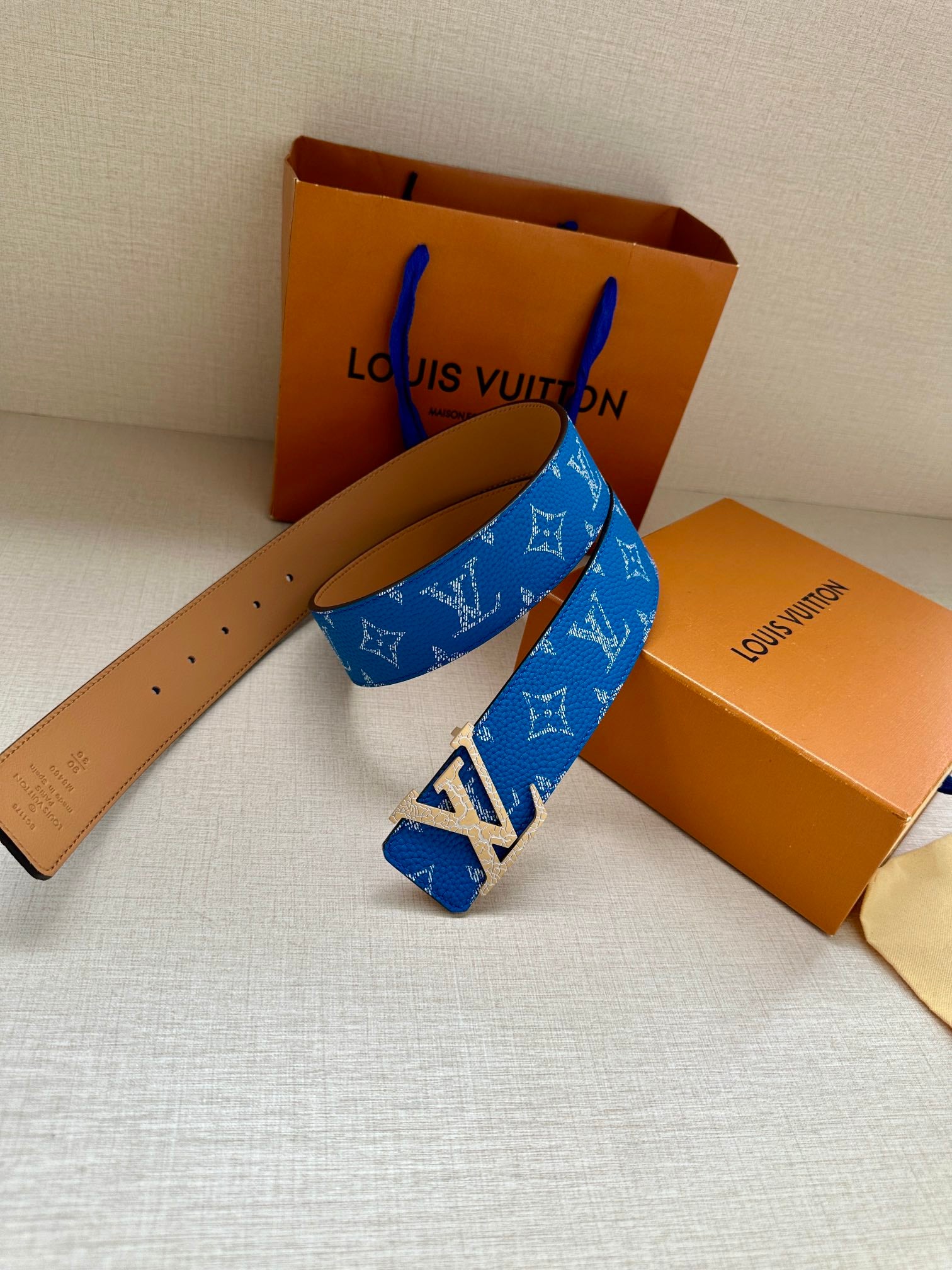 Blue monogram belt with tan leather strap and metal buckle