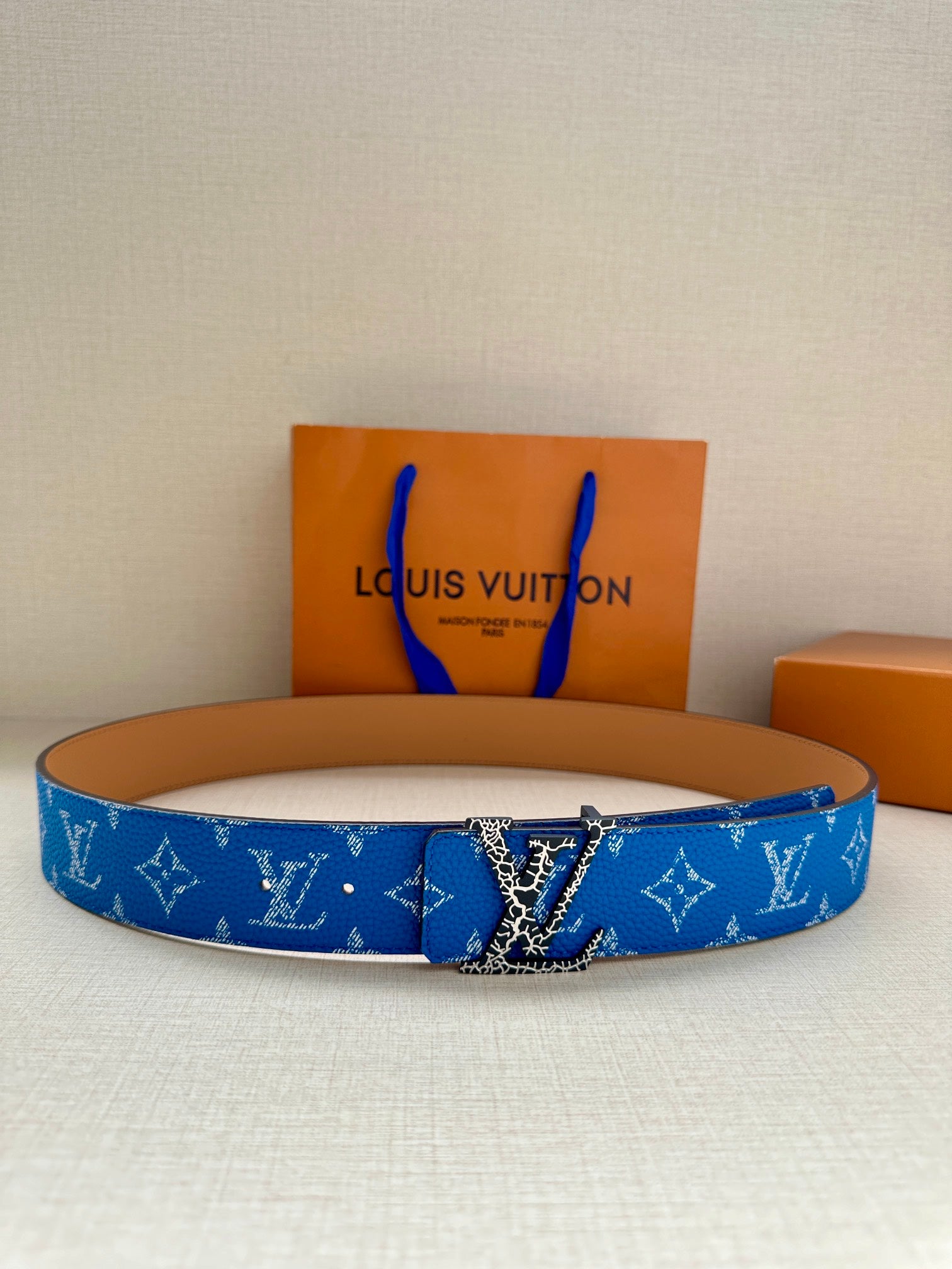 Blue monogram belt with metal buckle and tan keeper