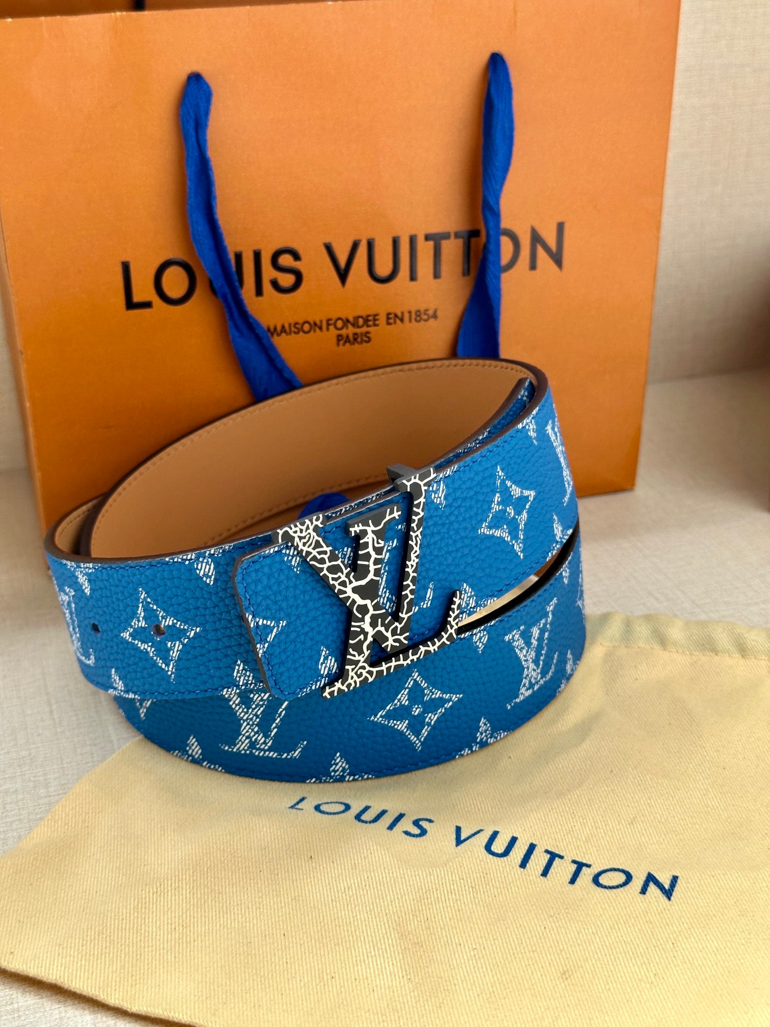 Blue monogram belt with metal buckle on tan leather backing