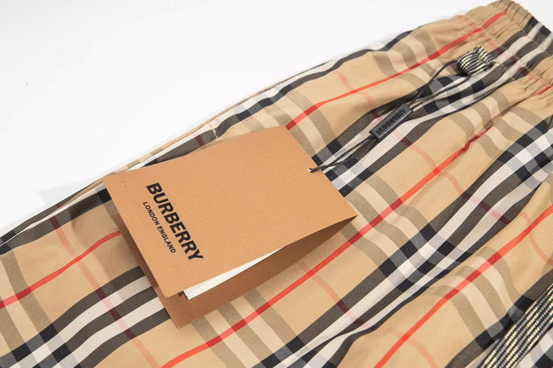 Burberry plaid shorts with Burberry label tag attached near waistband