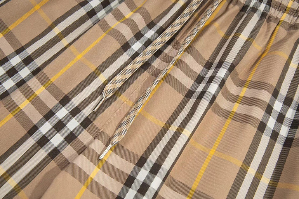Plaid shorts front with drawstring and stitched panel seam, beige black yellow checks