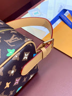 Monogram bag strap and brass buckle with tan edging and multicolor star motifs