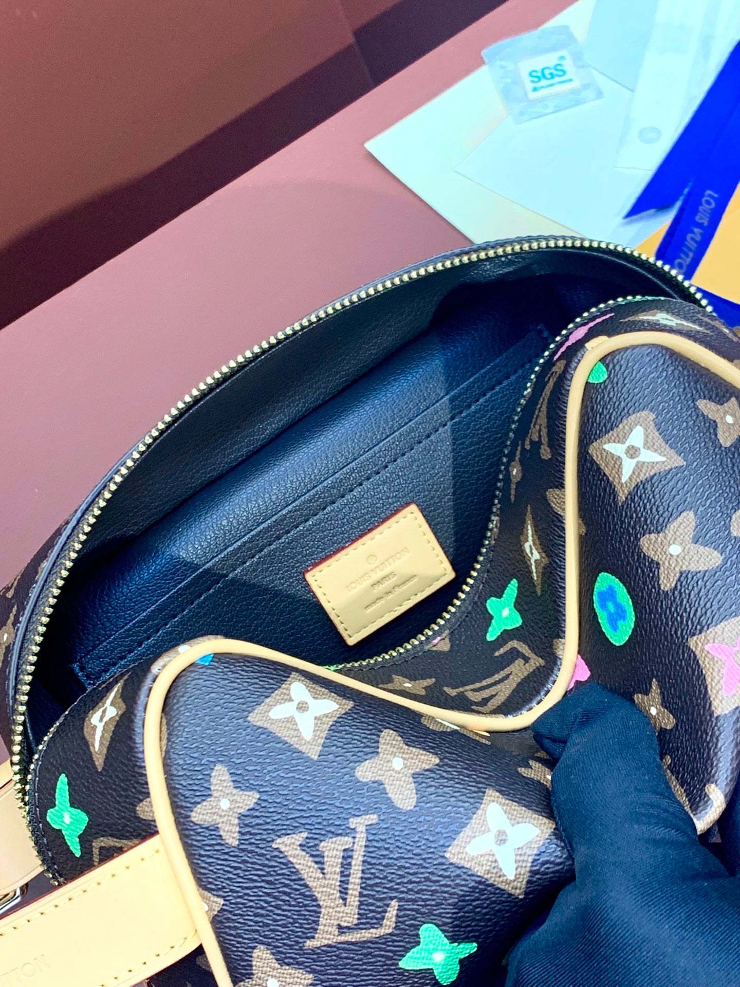 Inside view of monogram bag with blue fabric lining and cream leather patch