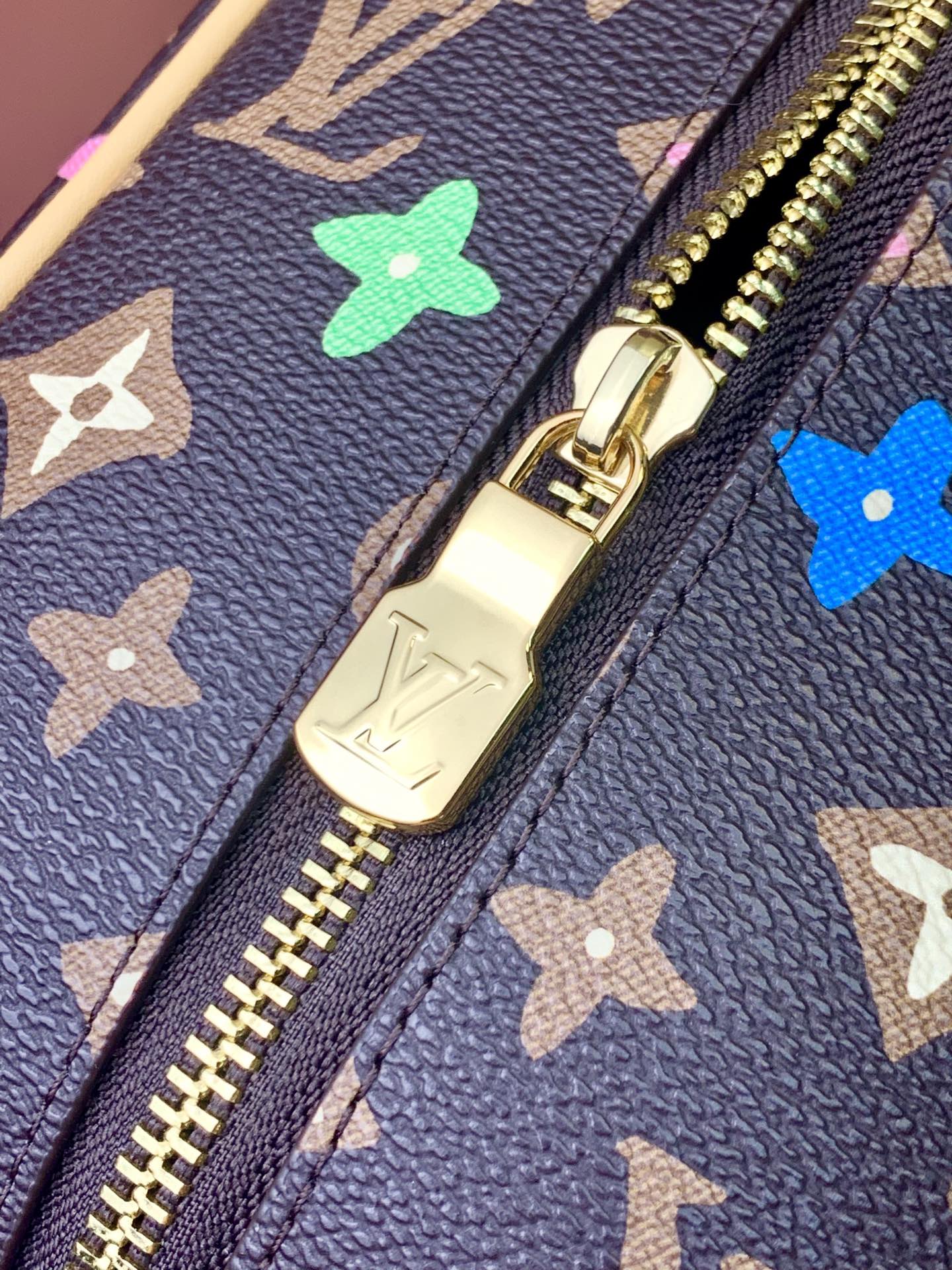 Navy monogram bag zipper and gold pull with multicolor star motifs