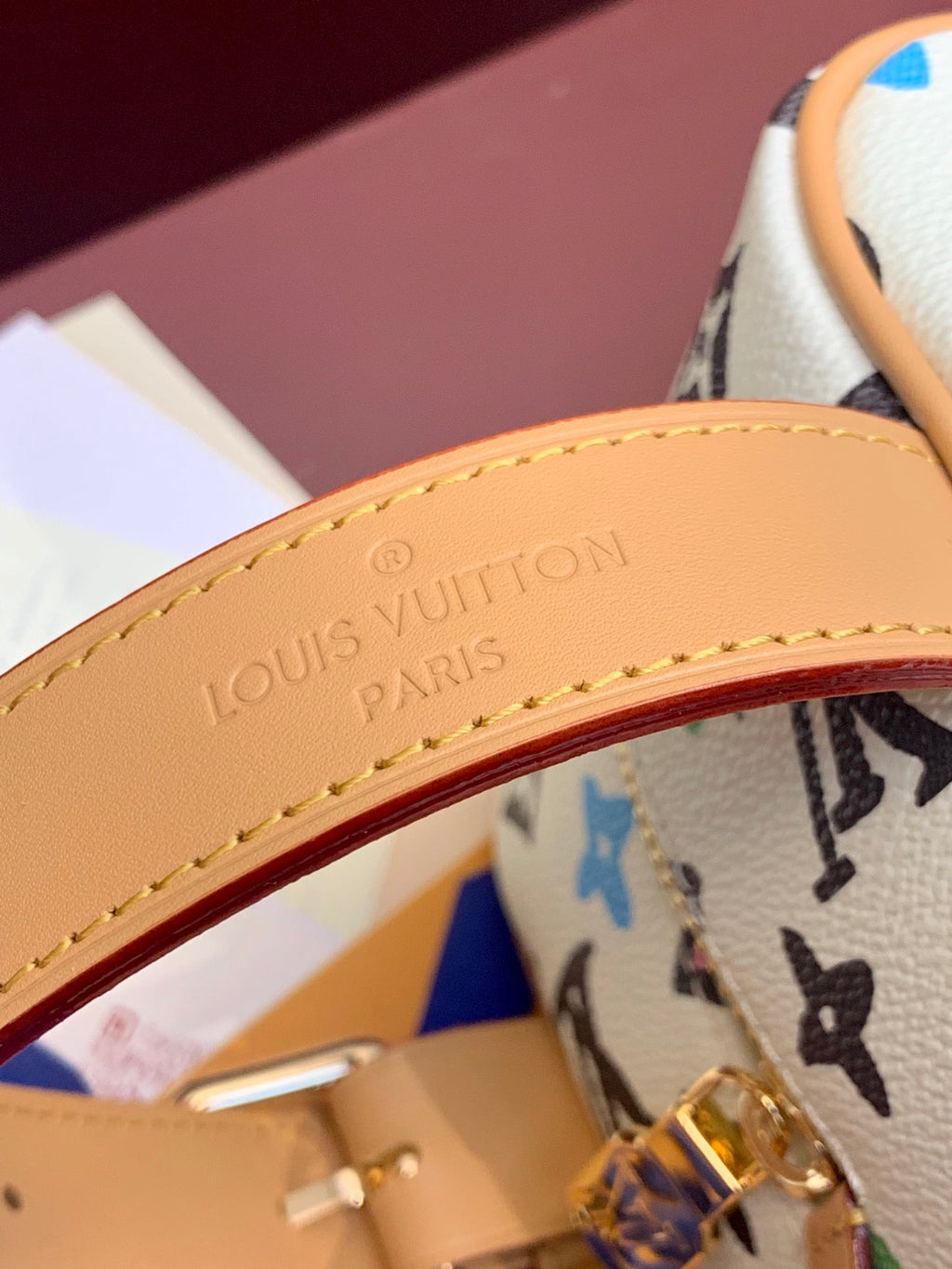 Louis Vuitton leather trim with embossed logo, tan edge stitching, gold zipper hardware