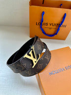 Louis Vuitton monogram belt with LV buckle, angled view on dark strap