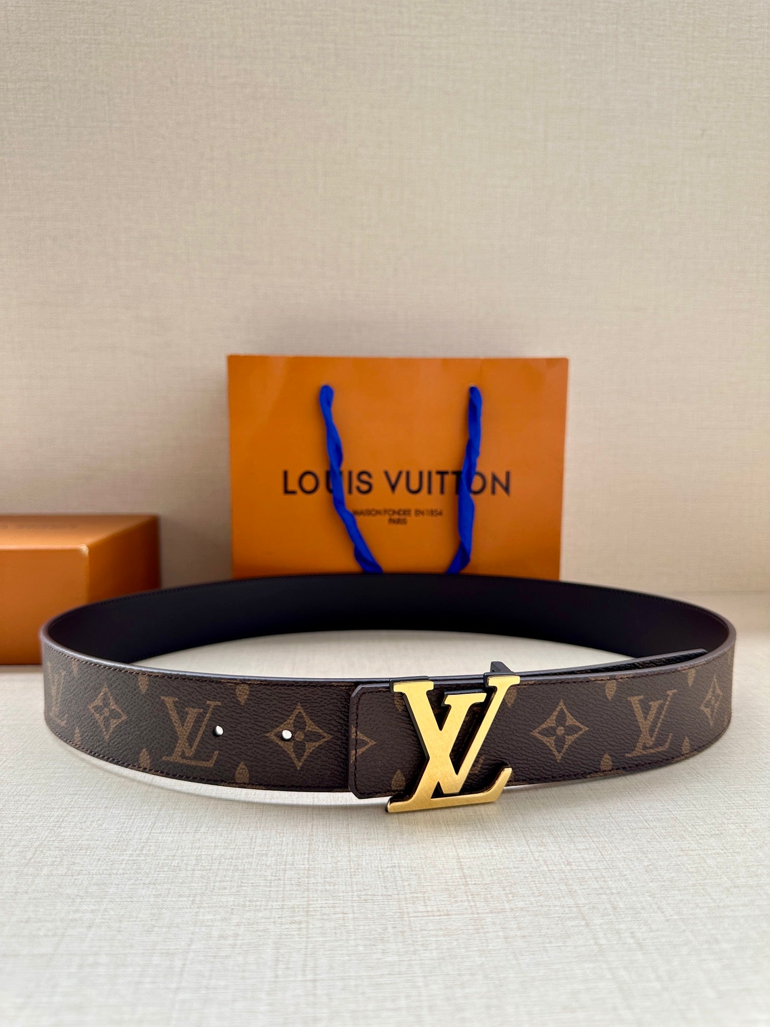 Louis Vuitton monogram belt with gold-tone LV buckle on dark strap