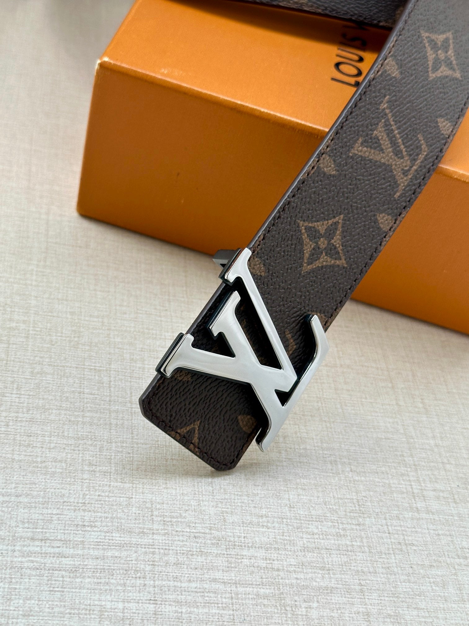 Monogram belt with large LV buckle and dark strap with metal keeper