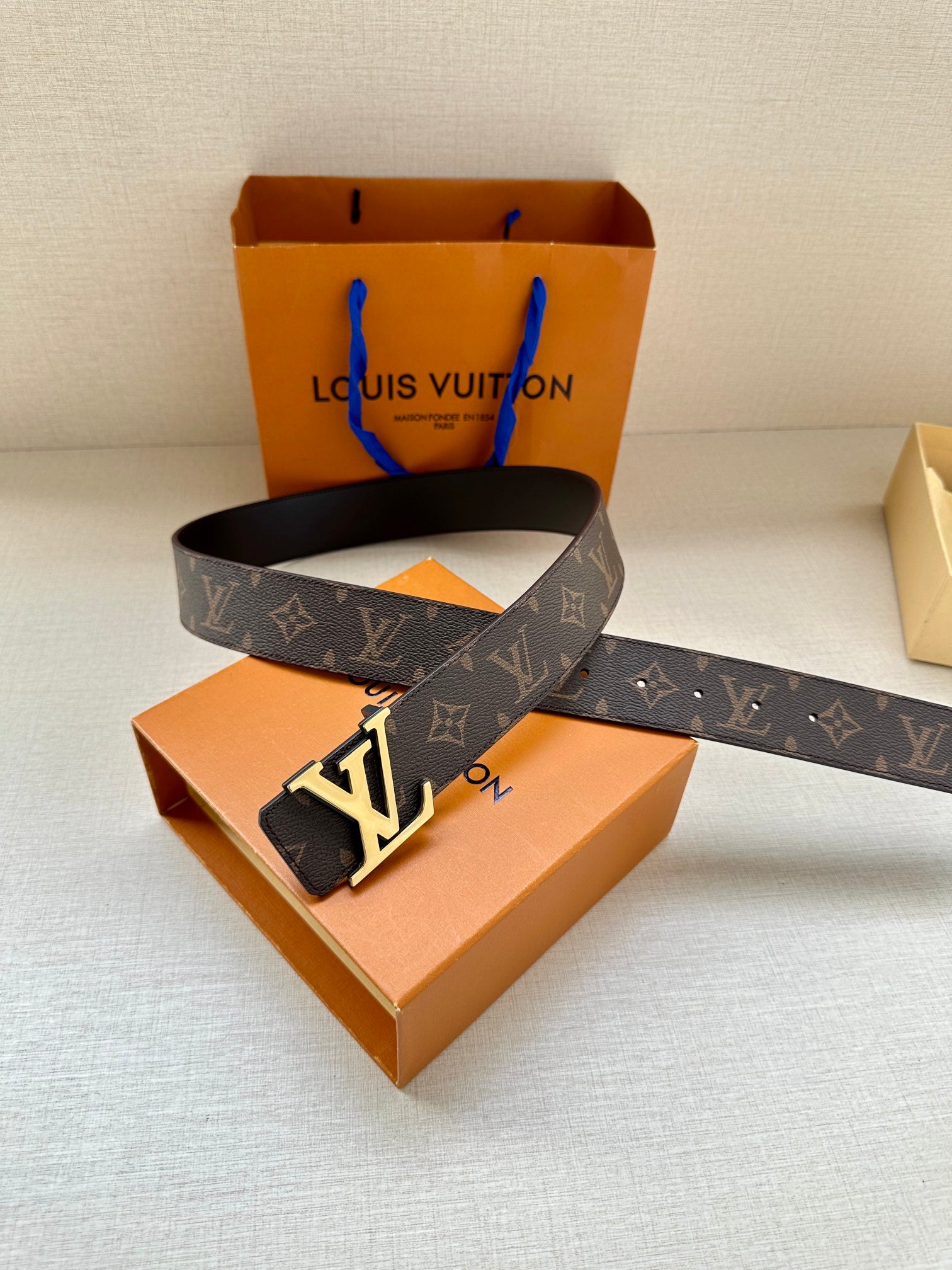 Louis Vuitton monogram belt with gold-tone LV buckle on dark leather strap