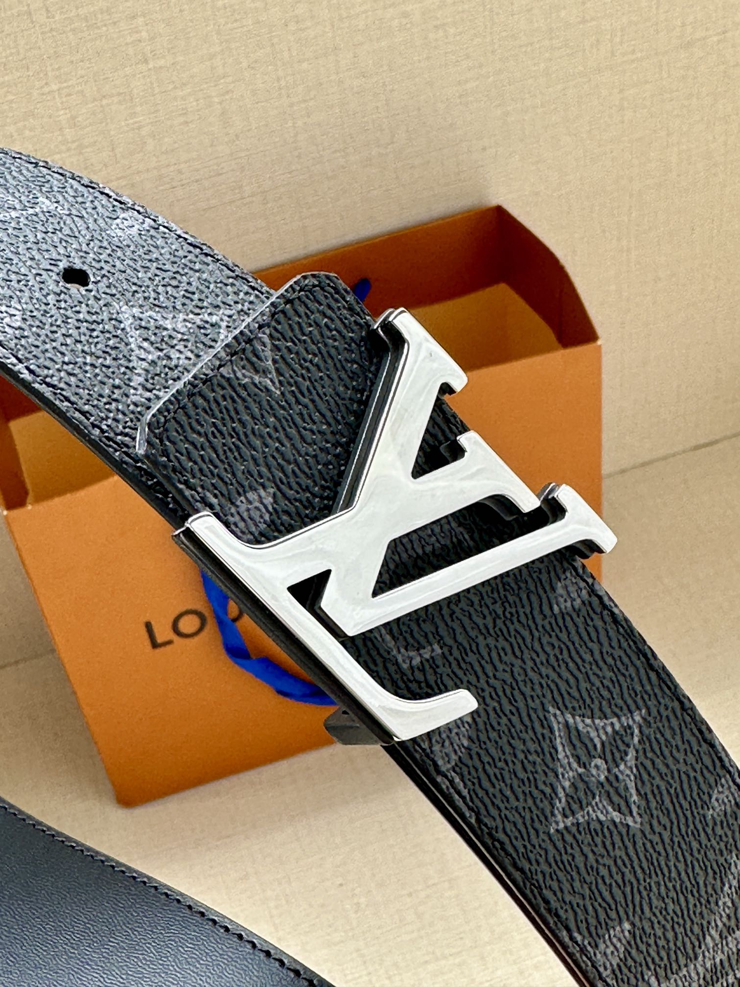 Dark monogram belt with wide silver-tone buckle and textured leather strap