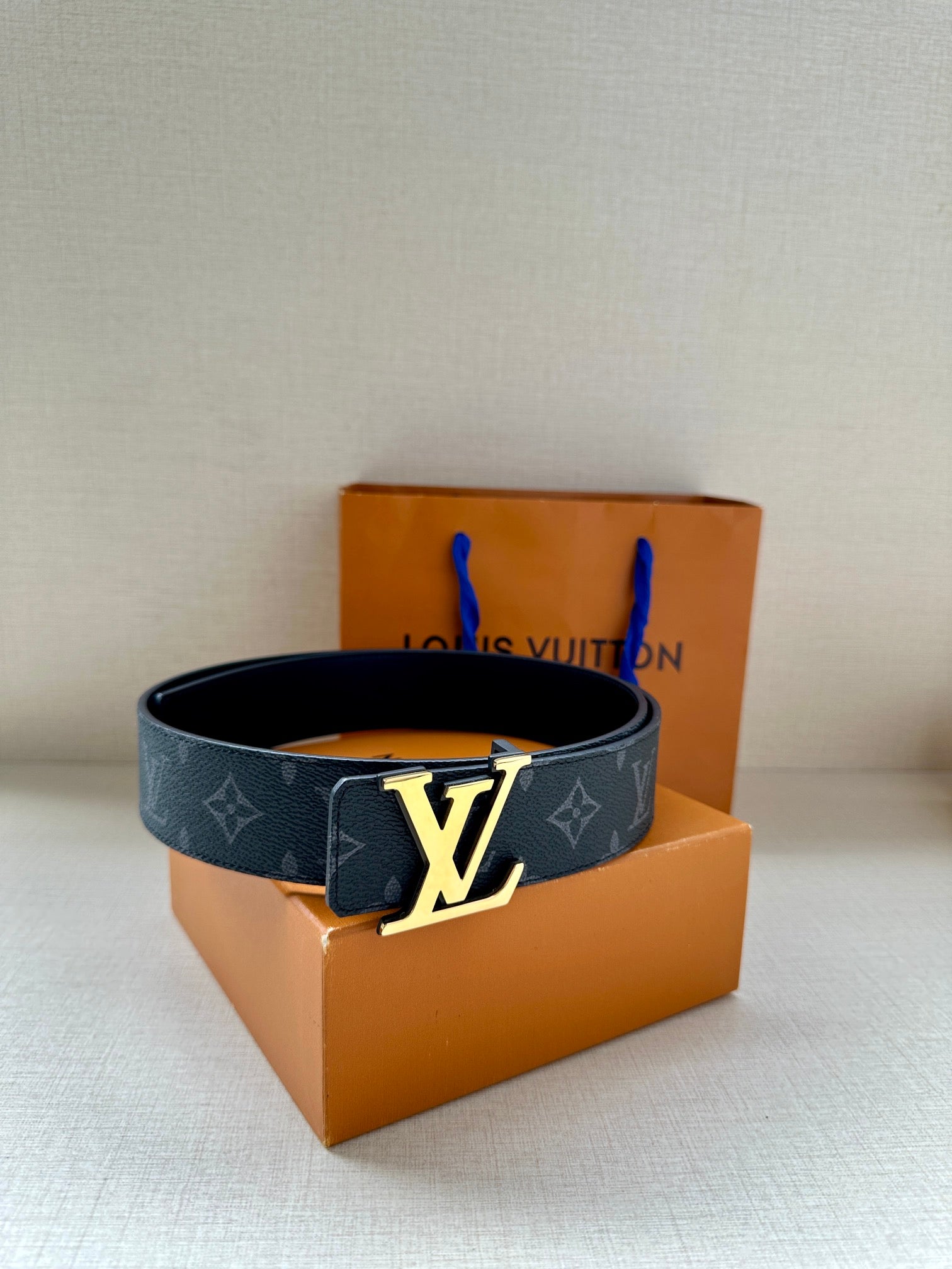 Navy monogram belt with gold-tone LV buckle on folded strap