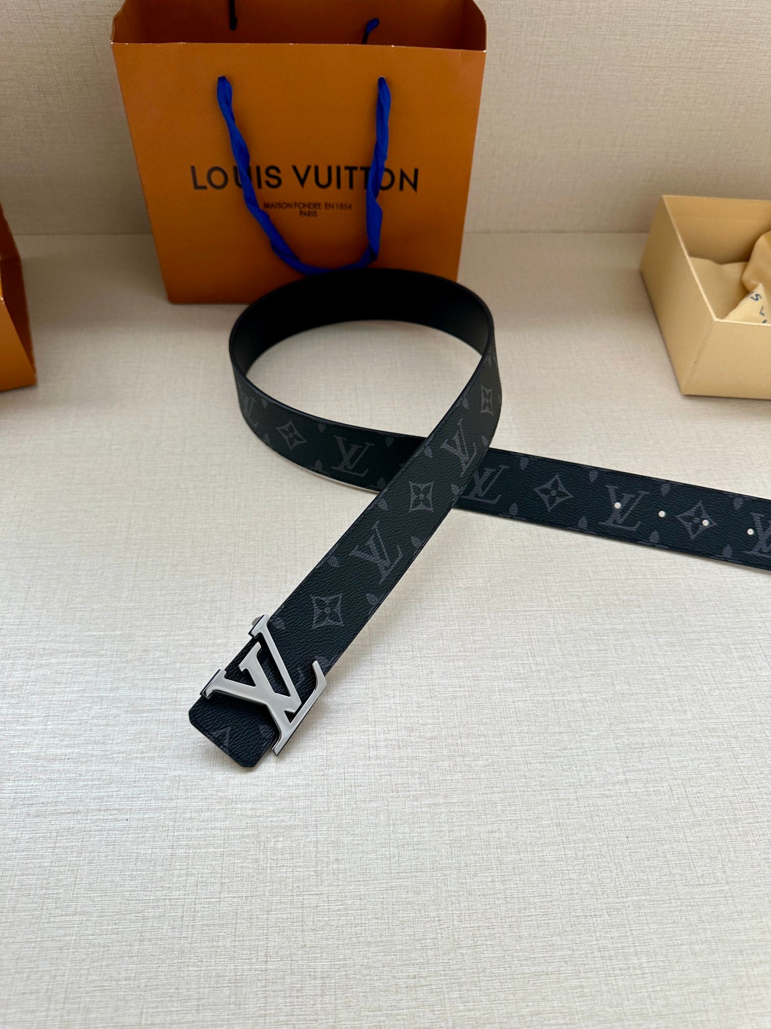 Dark monogram belt with oversized silver-tone LV buckle
