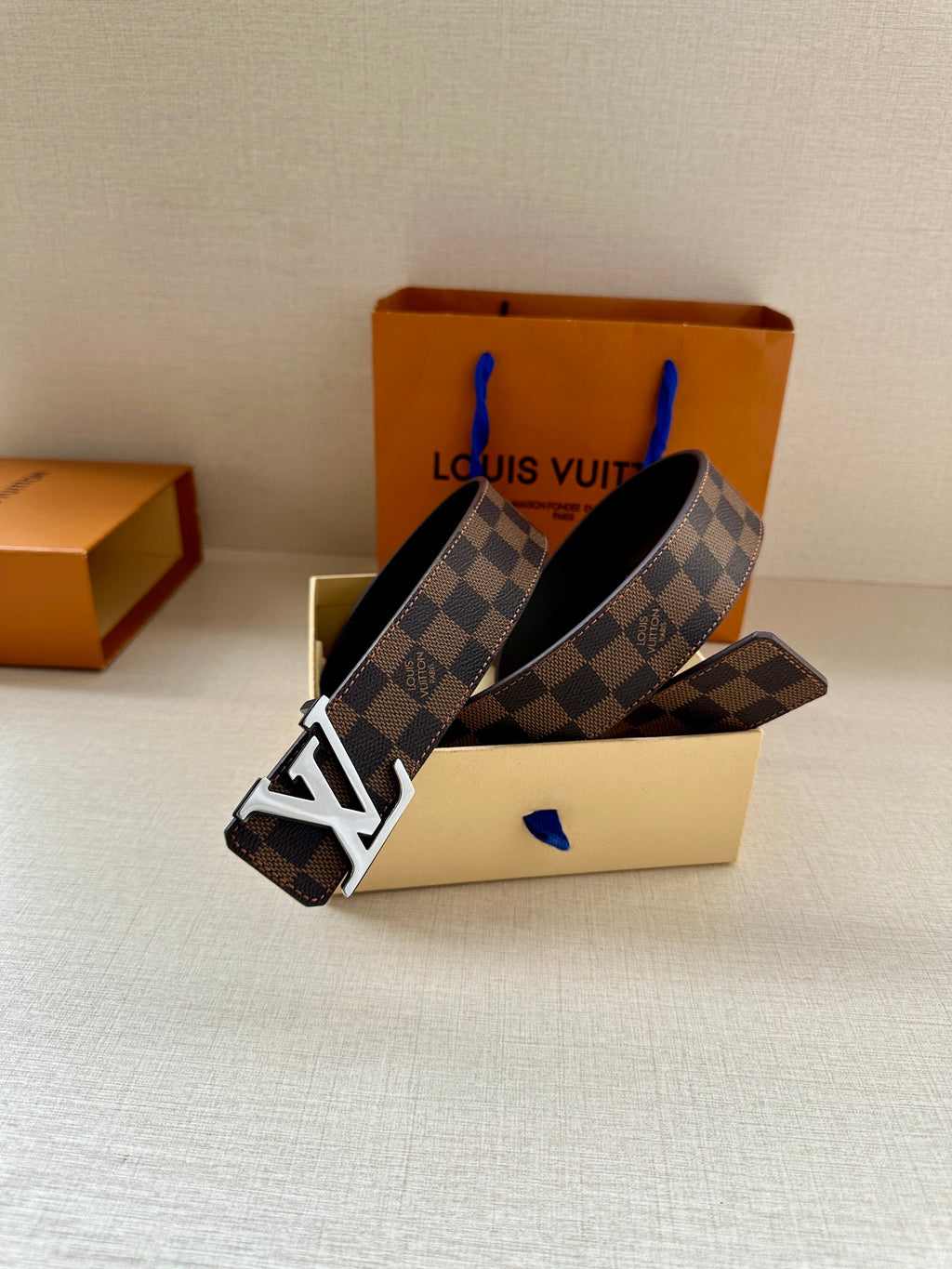 Louis Vuitton belt with dark damier print and gold-tone LV buckle, adjustable holes