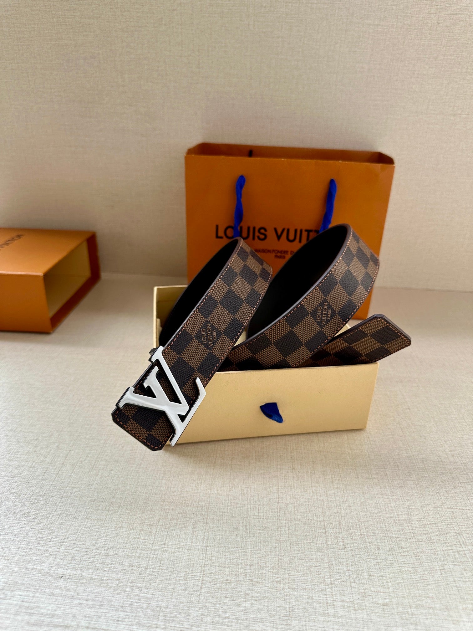 Louis Vuitton belt with dark damier print and gold-tone LV buckle, adjustable holes