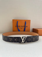 Louis Vuitton monogram belt with silver-tone LV buckle, dark canvas and tan leather lining.