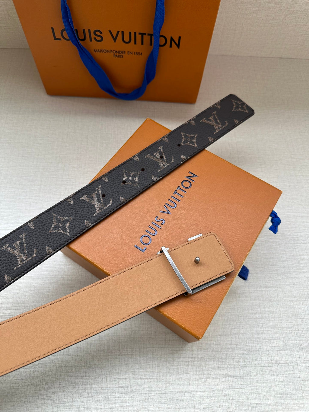 Louis Vuitton belt with monogram canvas strap, adjustable holes, silver buckle and tan backing.