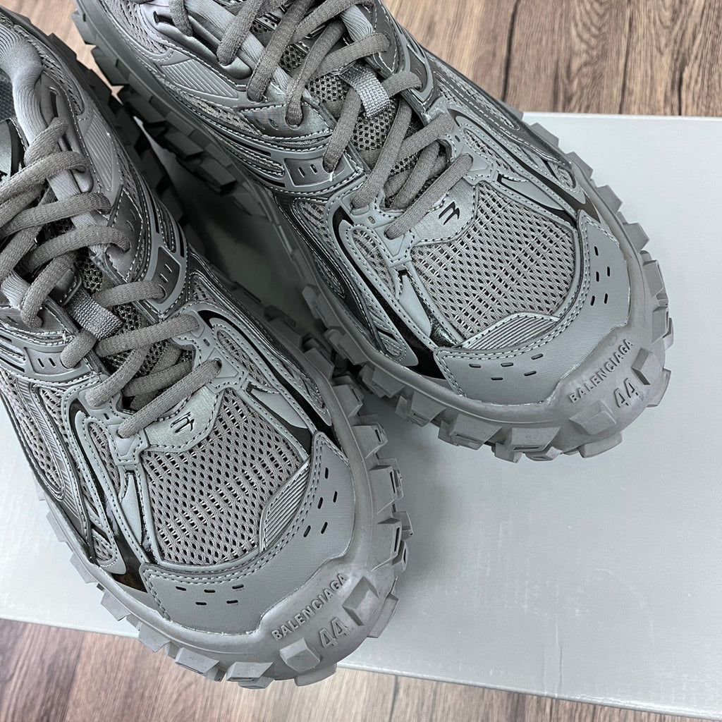 Gray Balenciaga sneakers showing mesh panels, lace-up front, and chunky tread midsole