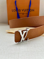 Tan leather belt close-up with silver LV buckle and embossed monogram texture