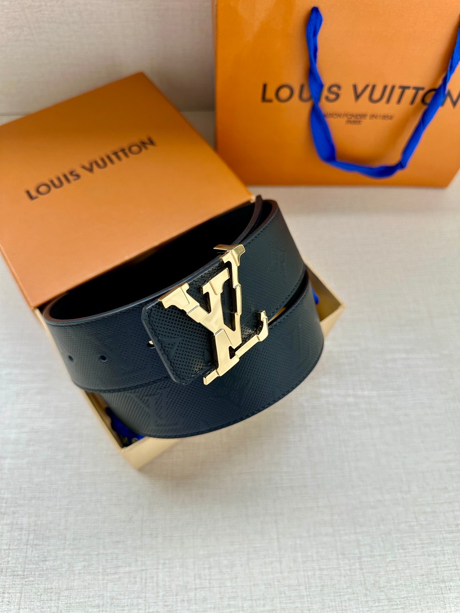 Dark blue leather belt with embossed logo and silver LV buckle