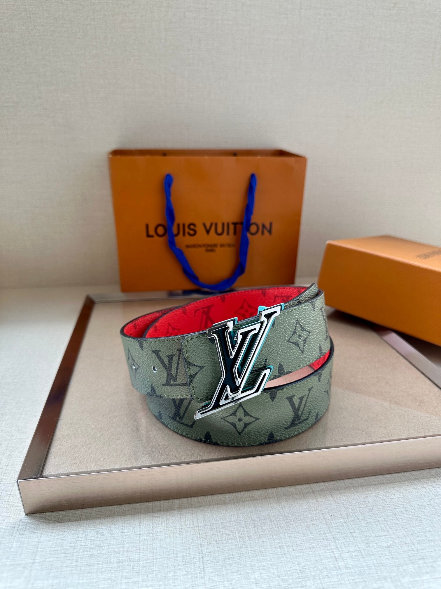 Louis Vuitton belt with green monogram strap and silver LV buckle, red underside