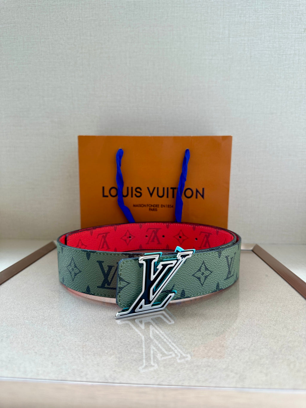 Louis Vuitton belt, green monogram strap with silver LV buckle and red lining