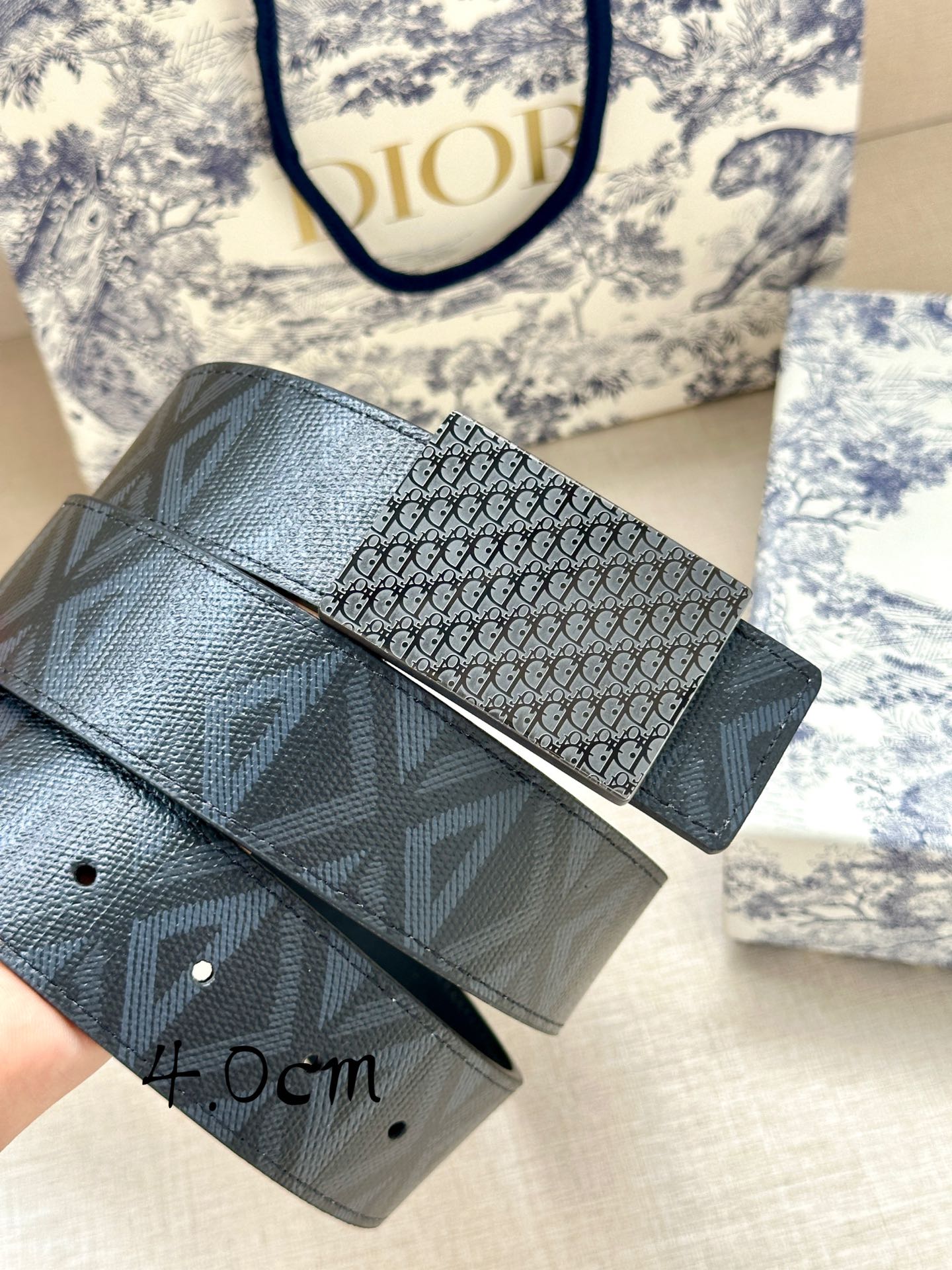 Dior belt close-up: monogram-patterned dark strap with rectangular buckle panel