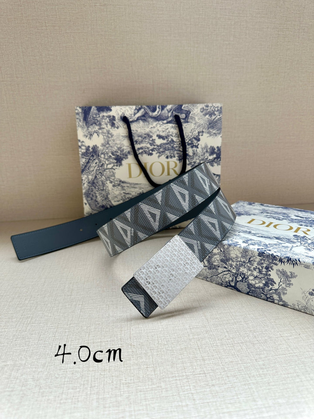 Dior belt with blue leather strap and gray jacquard logo band, belt folded