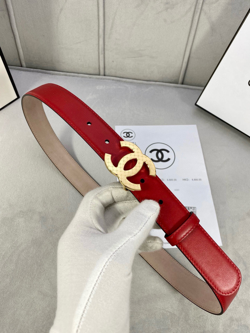 Chanel belt in red leather with gold-tone double C buckle and pin holes.