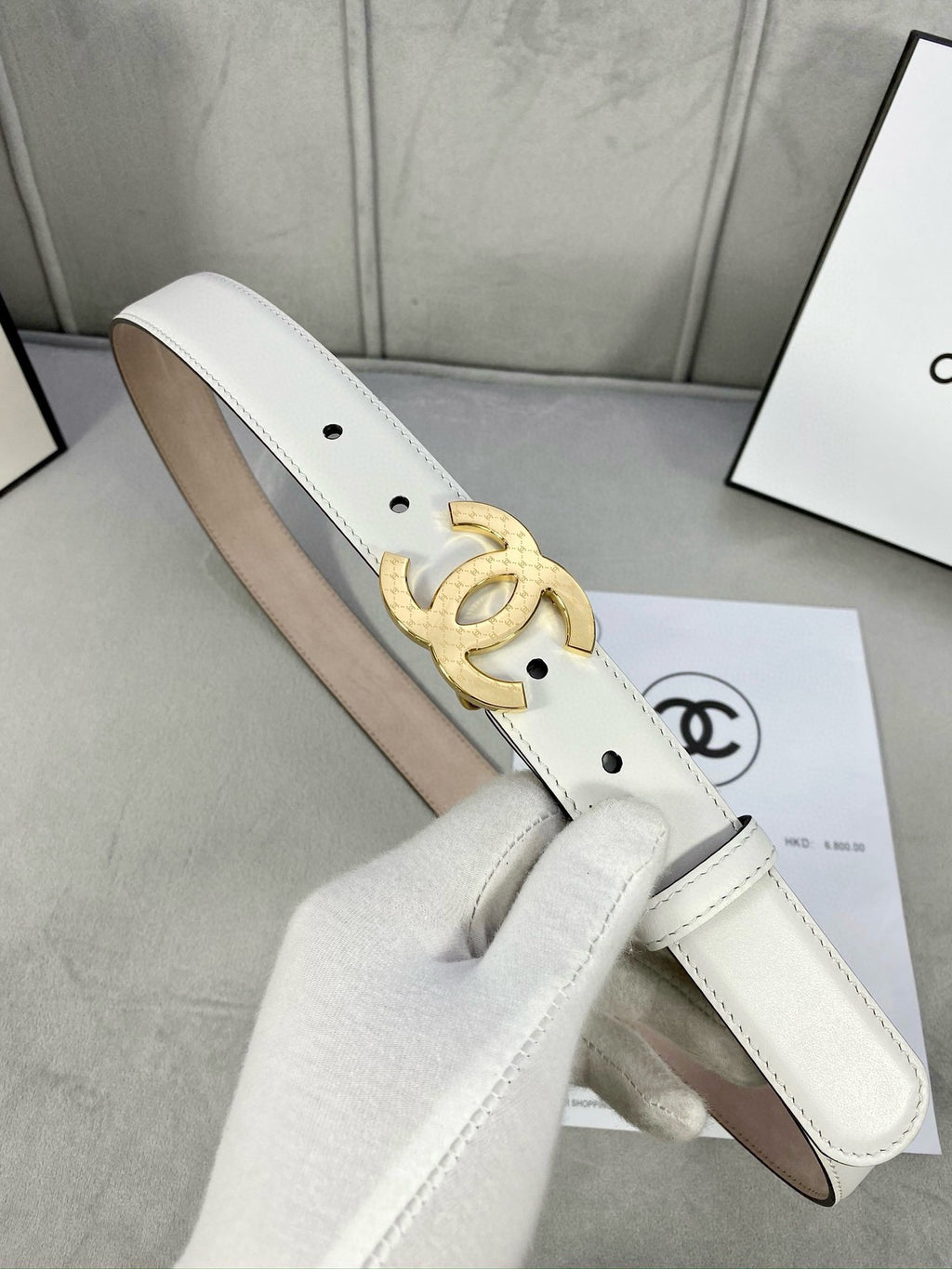 White leather belt with gold CC-style buckle and punched eyelets