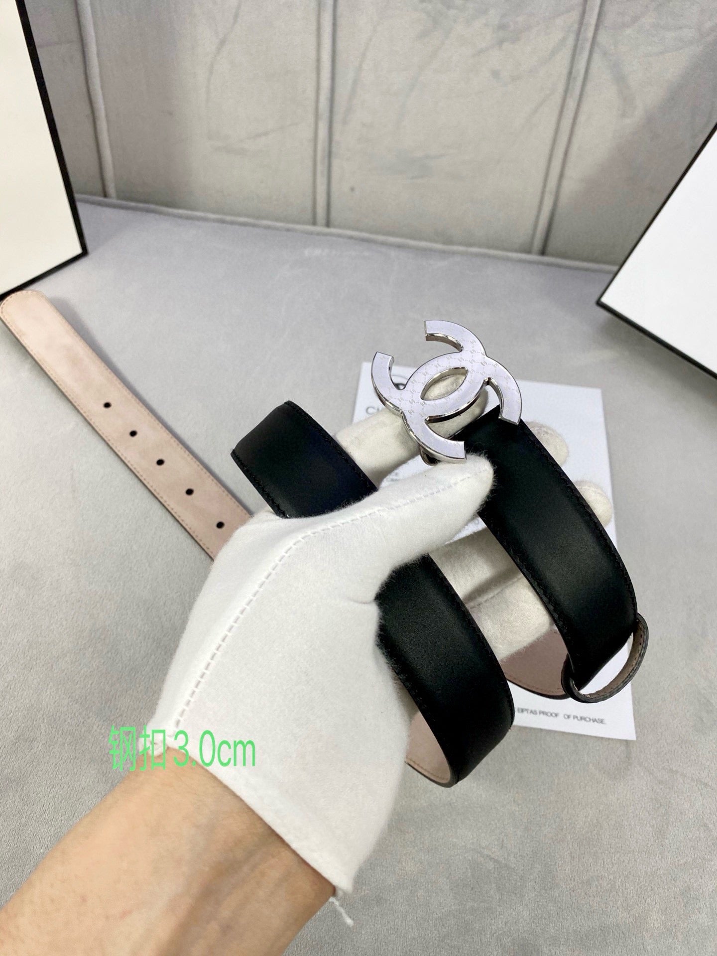 Black leather belt with silver-tone CC buckle and adjustable strap holes