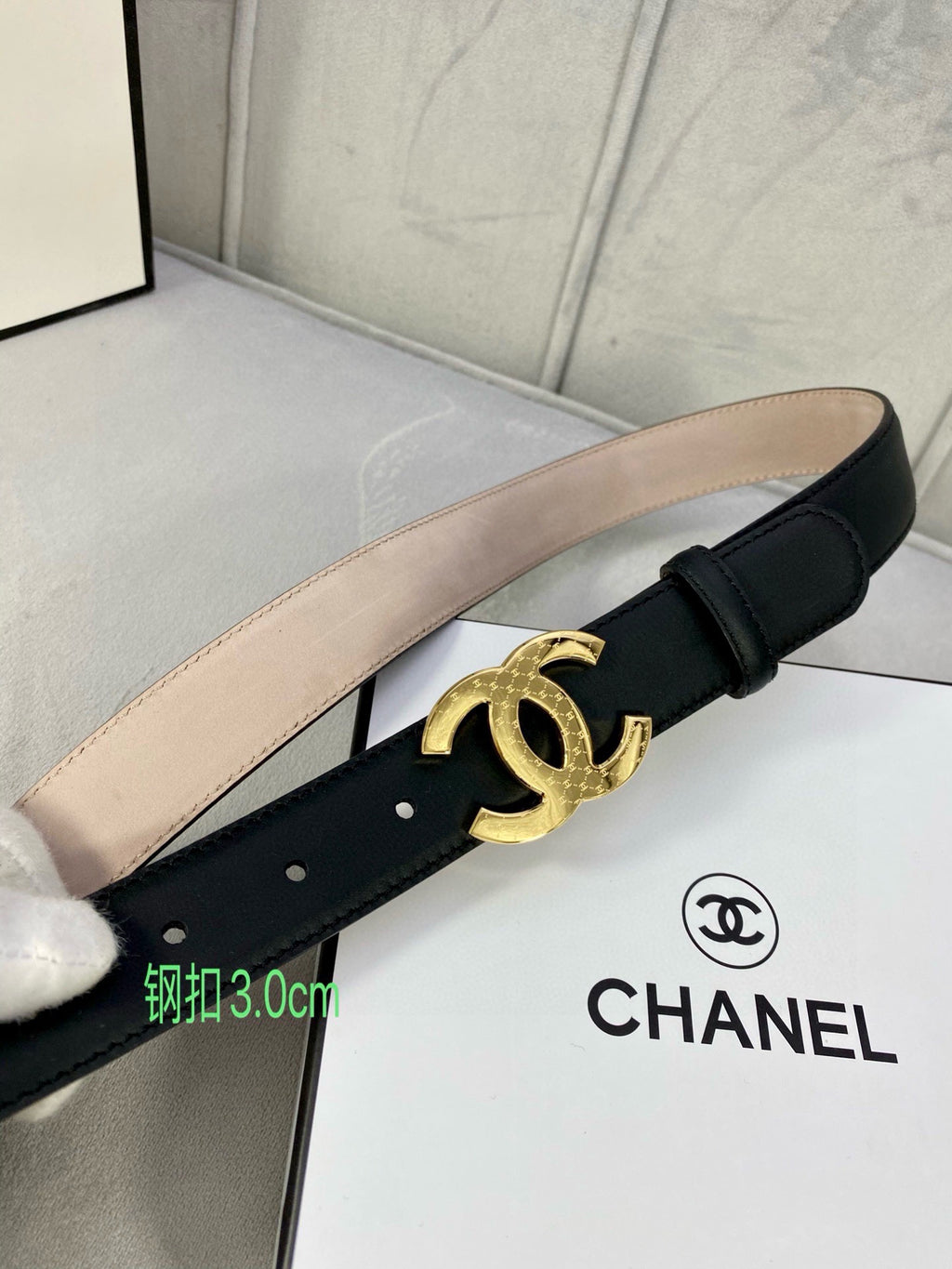 Black leather belt with gold-tone CC logo buckle and tan inner strap