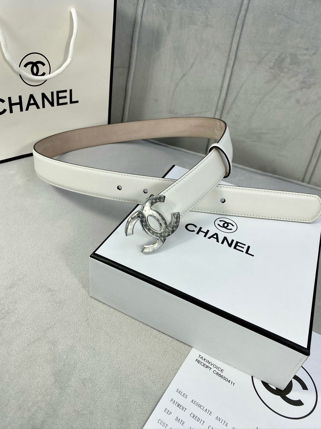 White leather belt with silver-tone CC buckle and adjustable strap holes