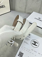 White leather belt with silver-tone CC buckle and folded strap on box